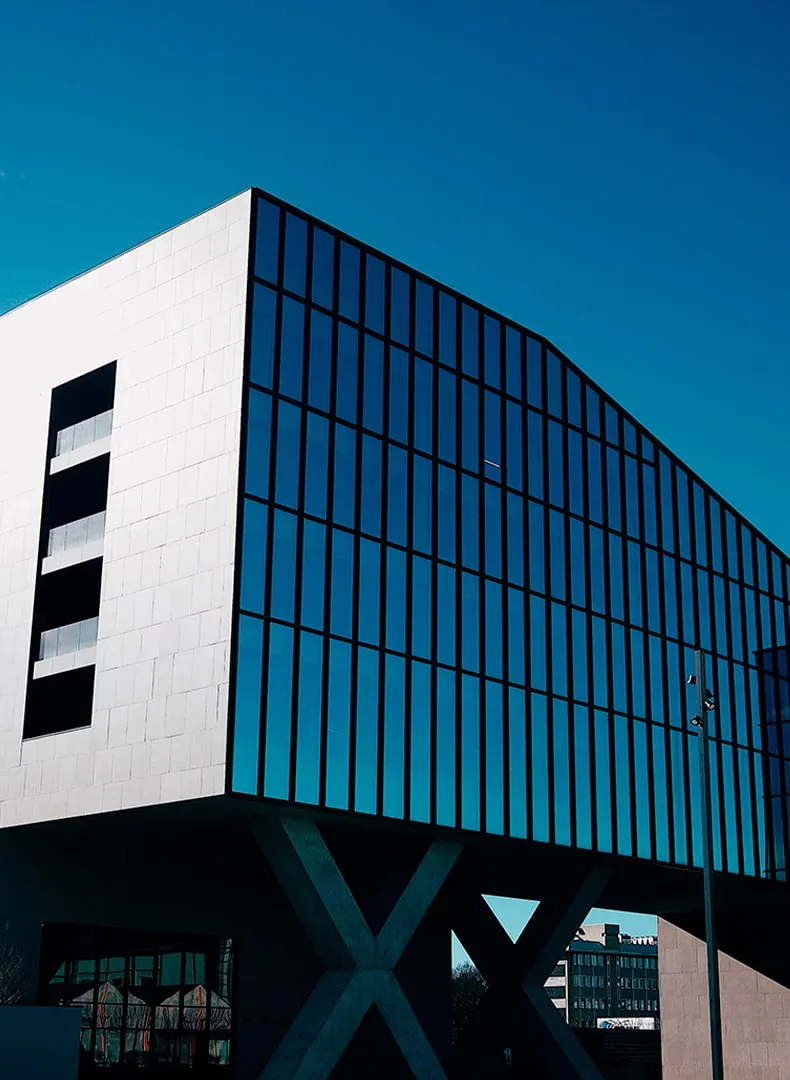 Modern glass-and-stone office building against a deep blue sky